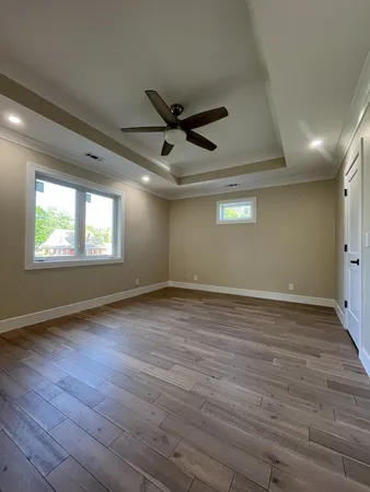a view of an empty room with a window and wooden floor
