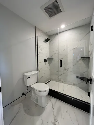 a bathroom with a toilet and a shower