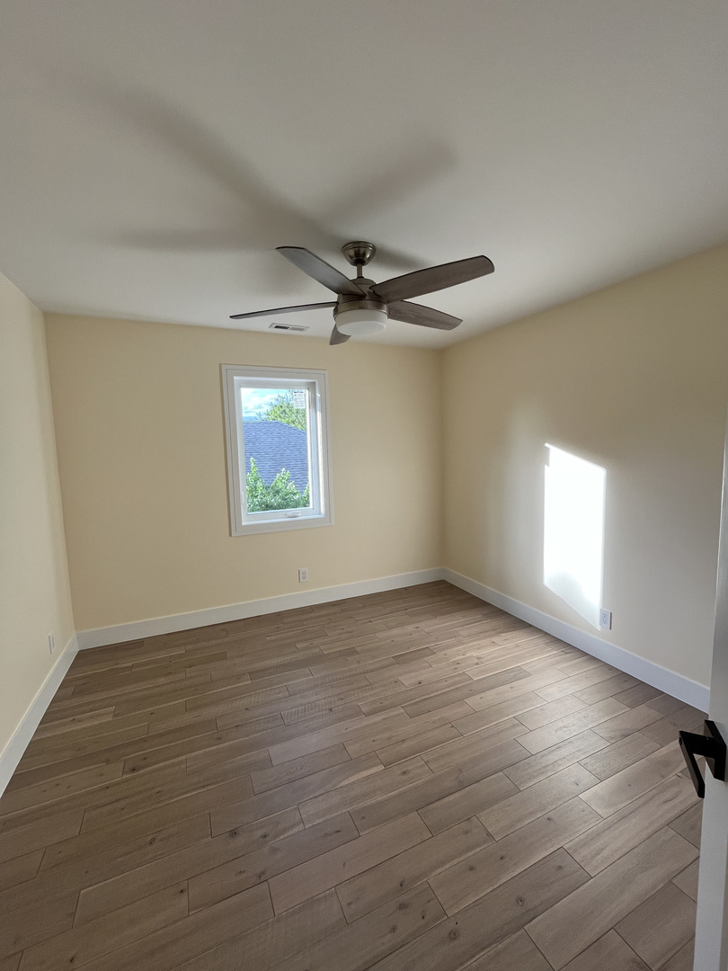 416 South 12th Avenue St. Charles, IL 60174 - Photo 9 of 20 an empty room with wooden floor a ceiling fan and windows