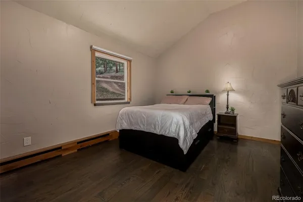 a bedroom with a bed wall painting and a window