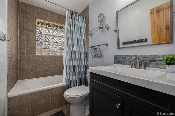 a bathroom with a sink a toilet a mirror and shower