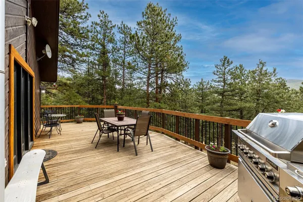 a view of a roof deck with table and chairs and wooden floor