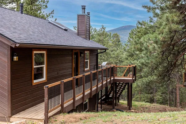 a view of a house with wooden deck front of house
