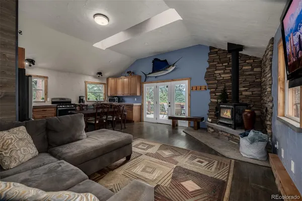 a living room with furniture large window and wooden floor