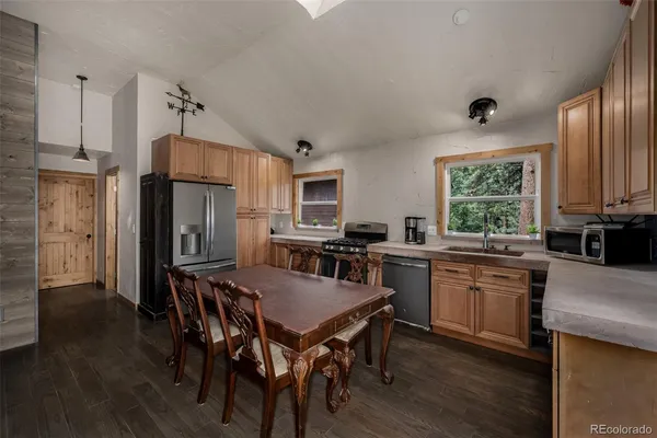 a kitchen with a table chairs refrigerator and cabinets