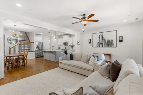 a living room with furniture and a dining table with kitchen view