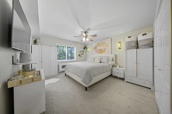 a bedroom with a bed a window and a chandelier