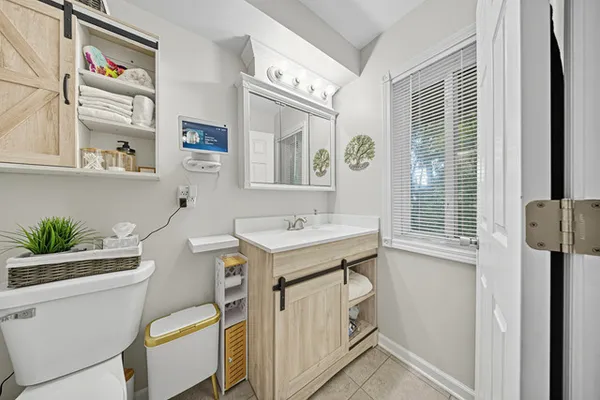 a bathroom with a sink a toilet and a window