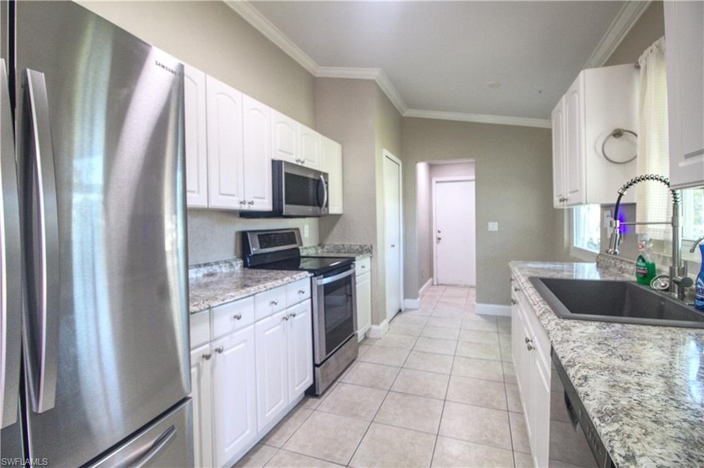 18257 Sycamore Road Fort Myers, FL 33967 - Photo 4 of 19 Kitchen featuring light stone countertops, appliances with stainless steel finishes, white cabinetry, and sink