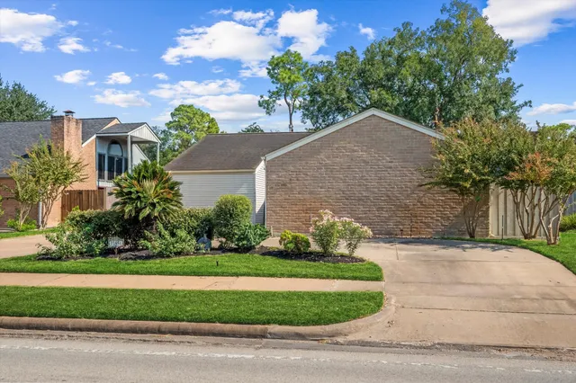 a front view of a house with a yard and potted plants