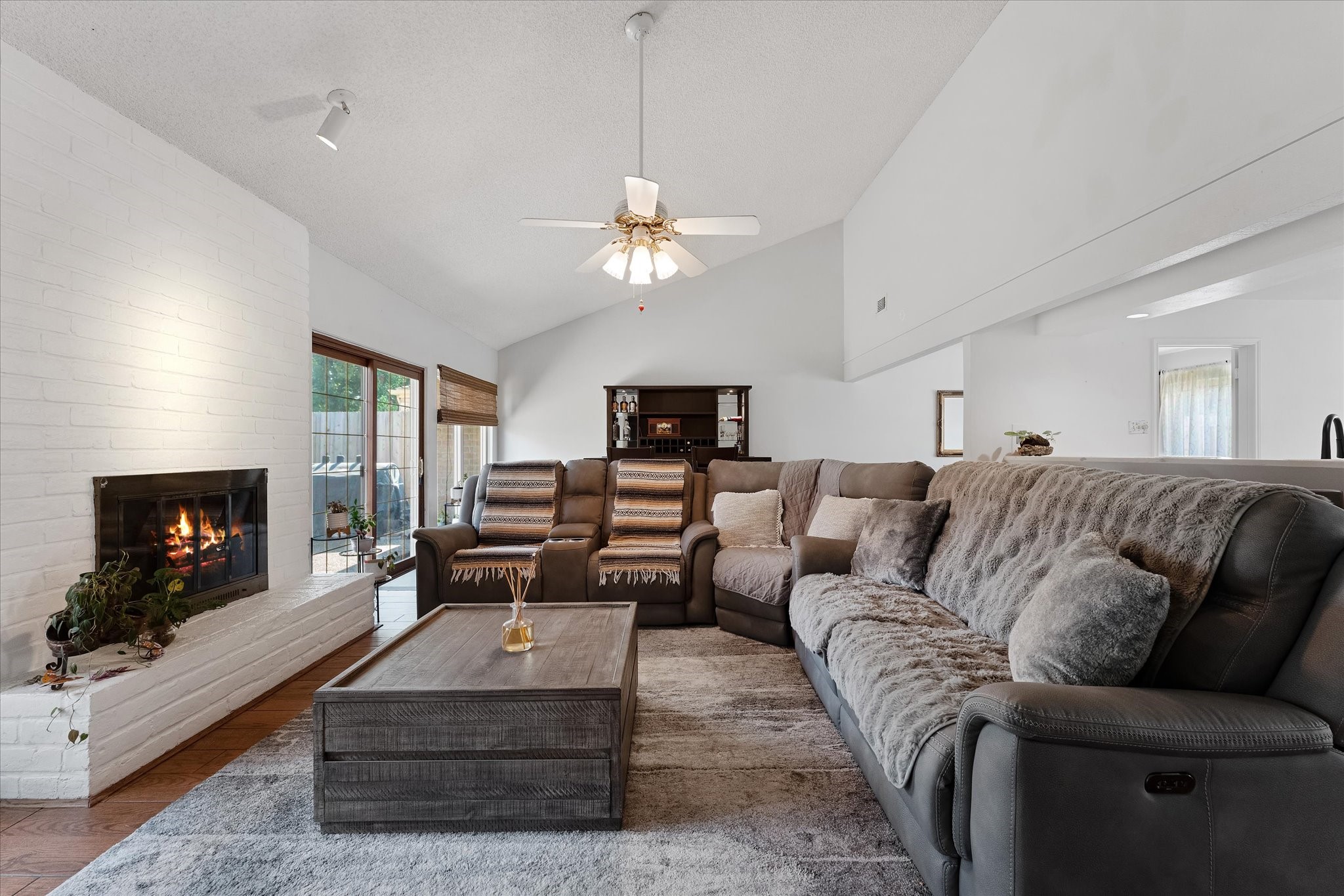 11854 Briar Forest Drive Houston, TX 77077 - Photo 11 of 21 a living room with furniture a fireplace and a chandelier