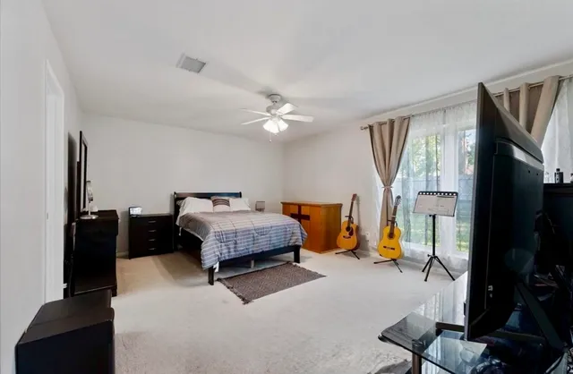 a bedroom with a bed and a flat tv screen on wall