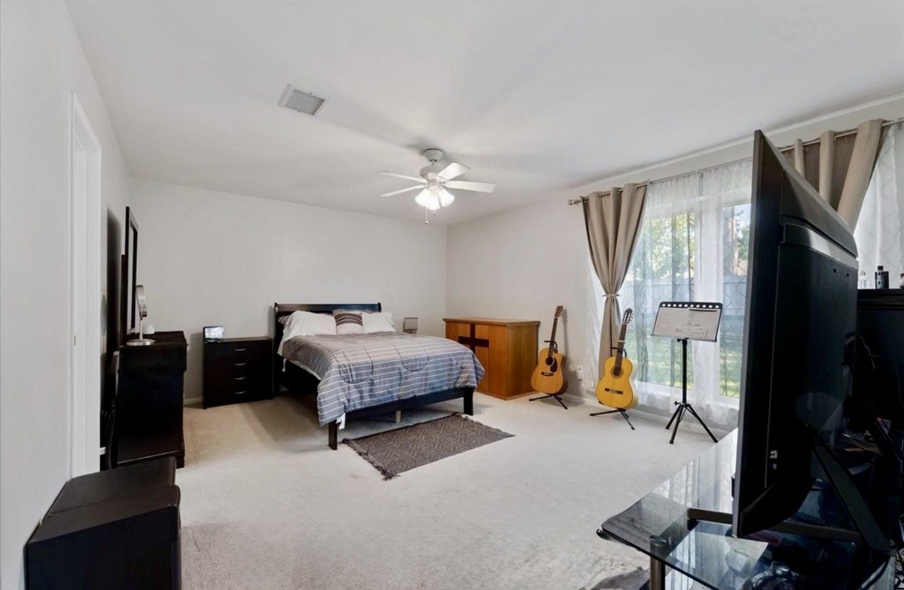 11854 Briar Forest Drive Houston, TX 77077 - Photo 16 of 21 a bedroom with furniture and a flat screen tv