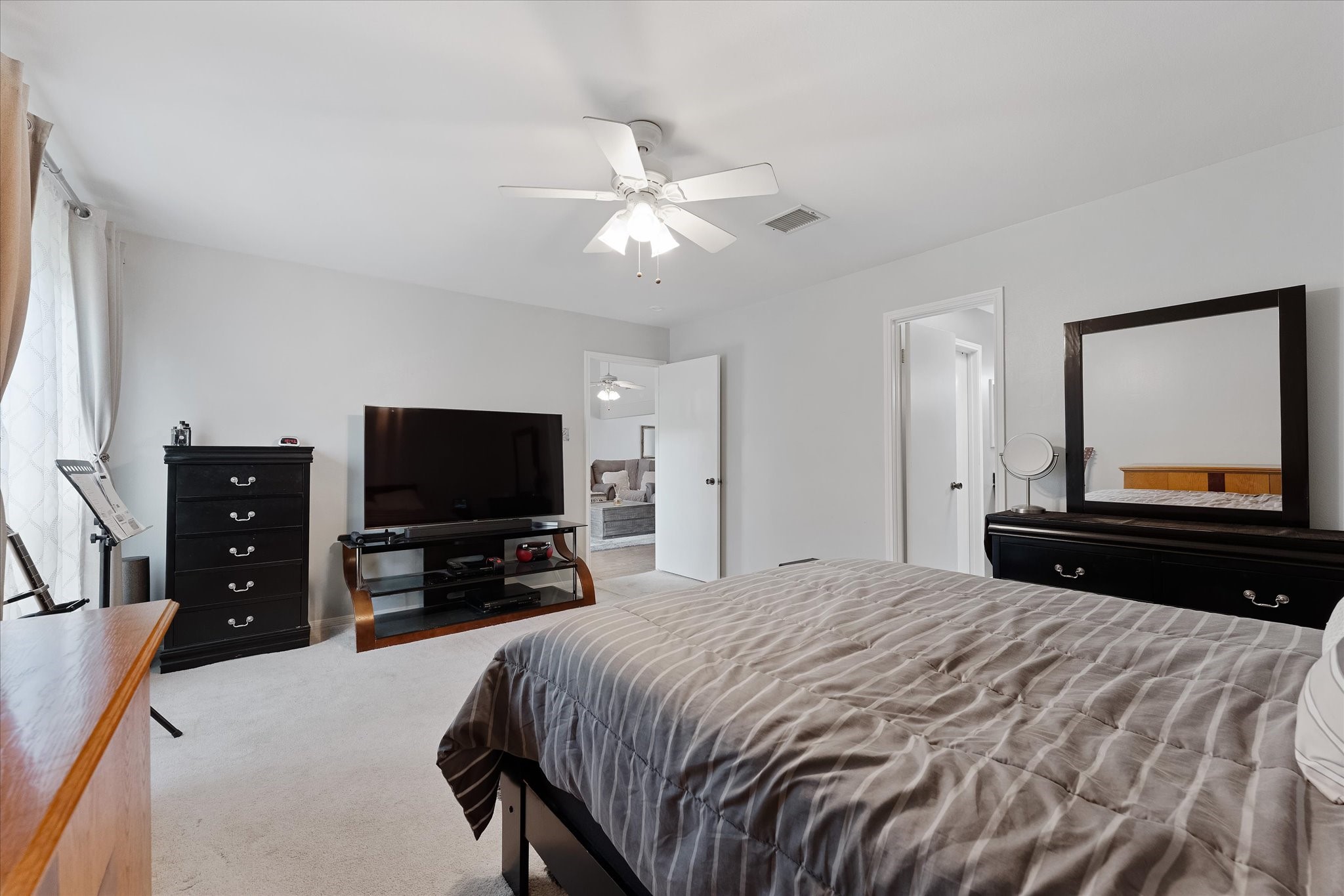 11854 Briar Forest Drive Houston, TX 77077 - Photo 17 of 21 a bedroom with a bed and a flat tv screen on wall