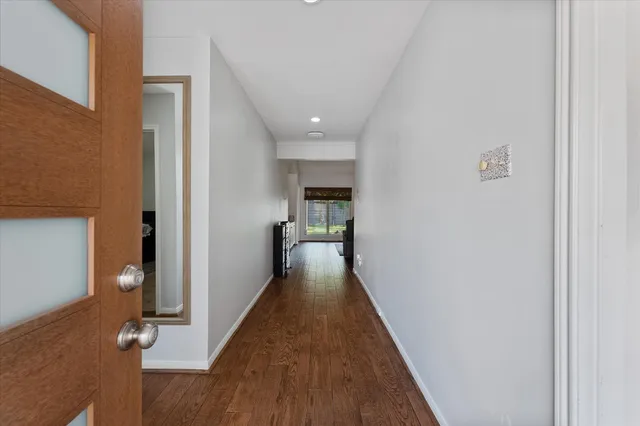 a view of a hallway with wooden floor and closet
