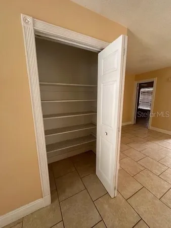 a view of walk in closet with empty racks