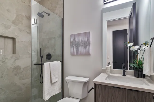 a bathroom with a sink a toilet and shower