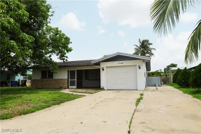 a front view of house with yard and trees