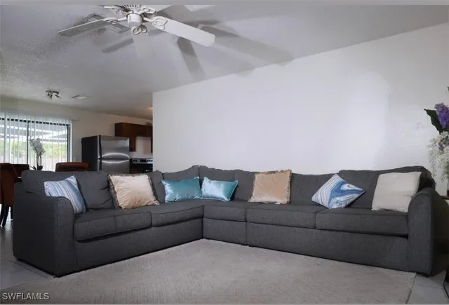 a living room with furniture and a ceiling fan