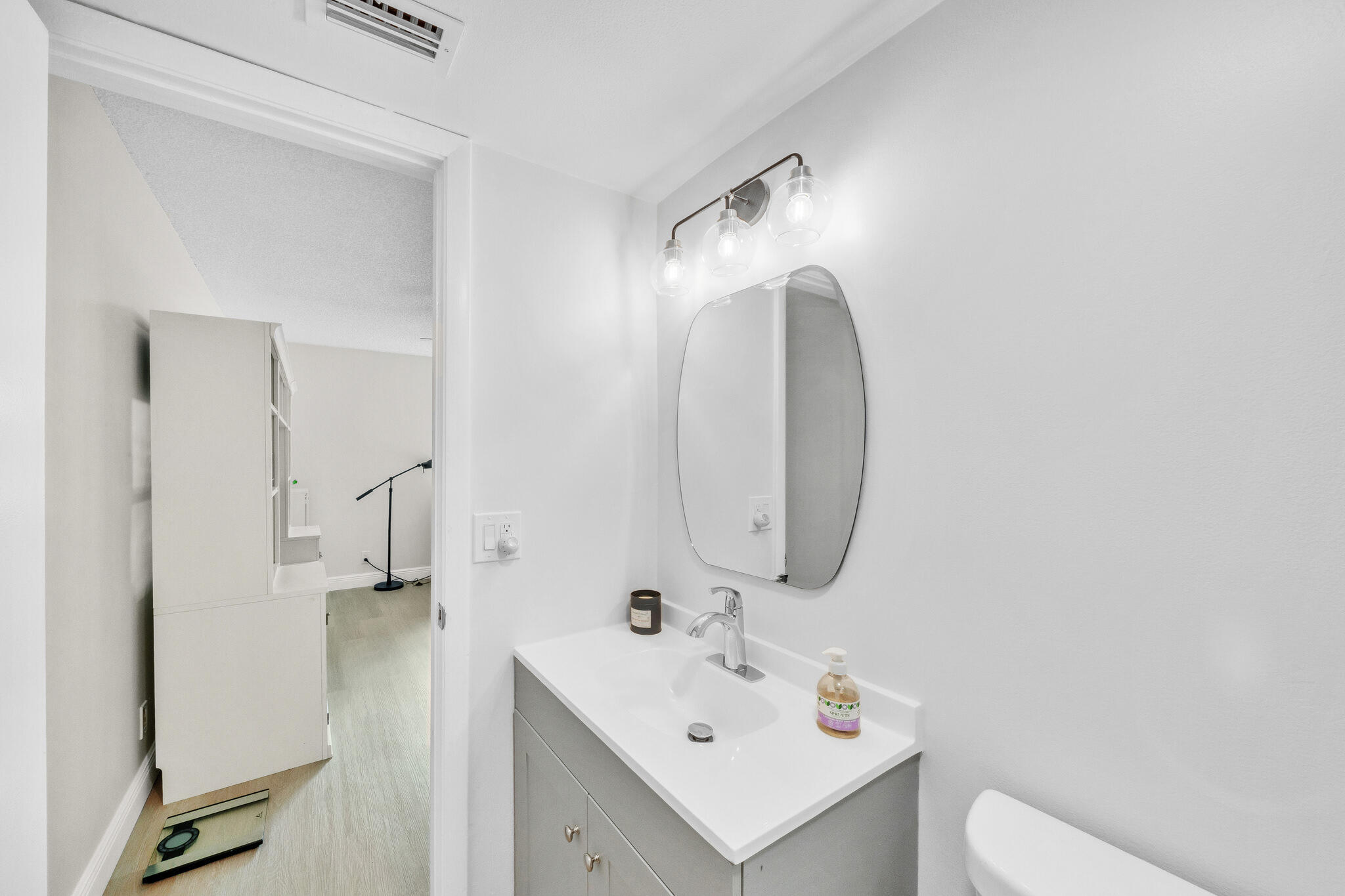 22136 Palms Way, Unit 103 Boca Raton, FL 33433 - Photo 23 of 42 a bathroom with a sink a toilet and a mirror