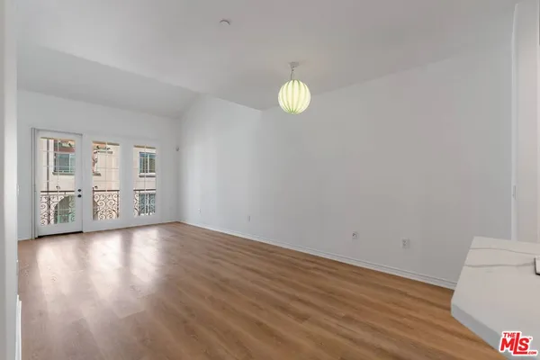 a view of a kitchen with wooden floor and a window