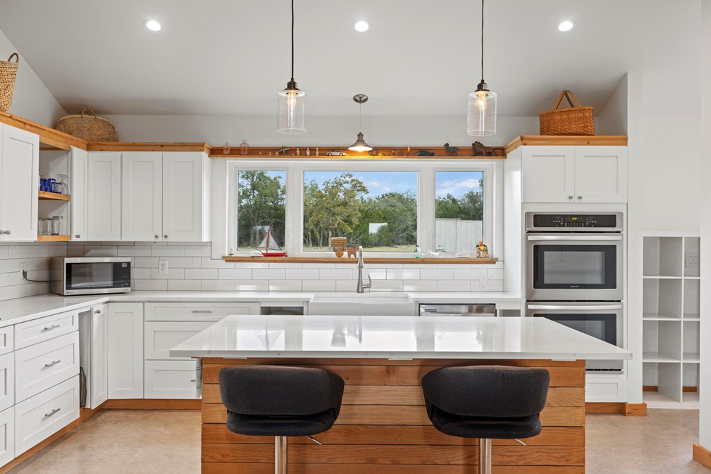 456 Colt Valley Road Fredericksburg, TX 78624 - Photo 12 of 46 a kitchen with stainless steel appliances granite countertop a sink a stove and a microwave