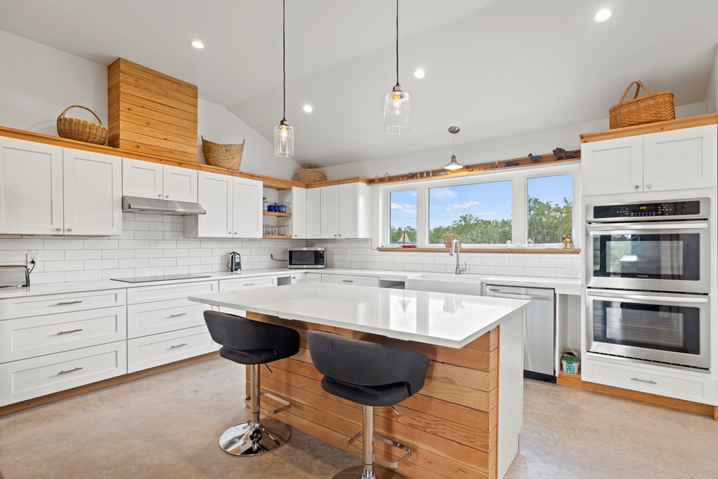 456 Colt Valley Road Fredericksburg, TX 78624 - Photo 16 of 46 a kitchen with stainless steel appliances granite countertop a sink a stove and a microwave