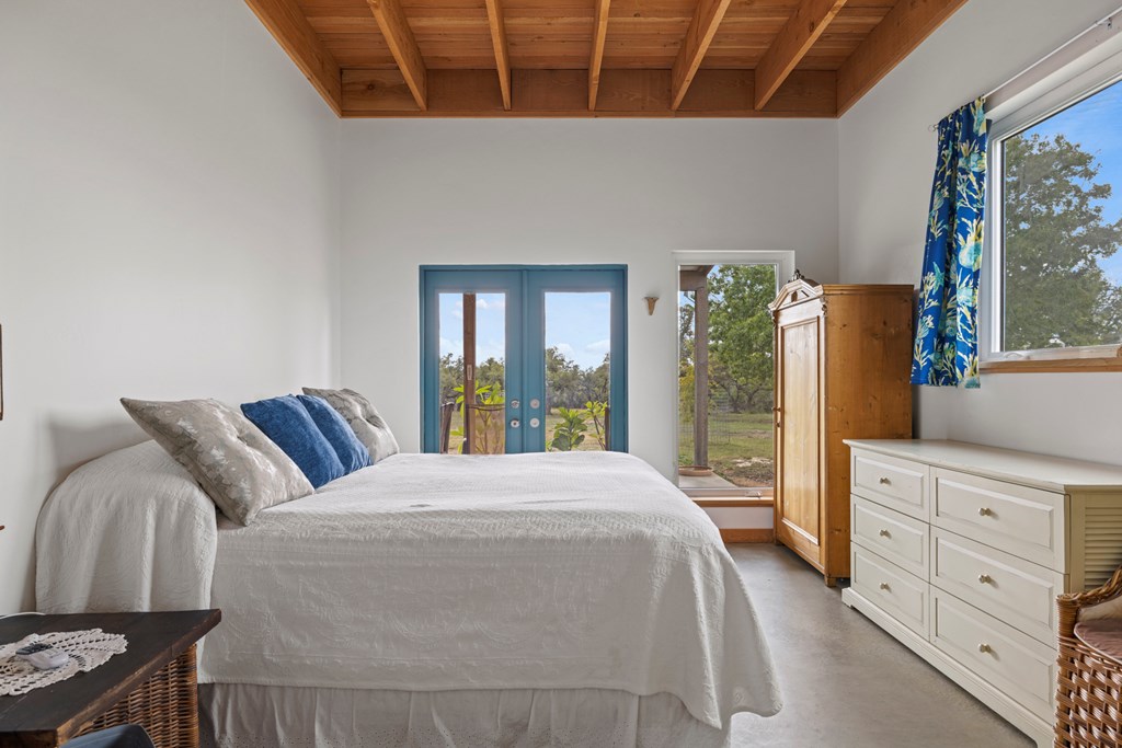 456 Colt Valley Road Fredericksburg, TX 78624 - Photo 19 of 46 a bedroom with a large bed and a window