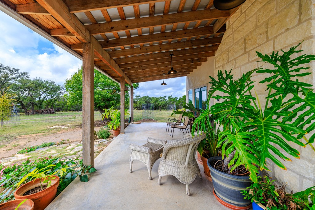 456 Colt Valley Road Fredericksburg, TX 78624 - Photo 6 of 46 a view of a patio with table and chairs potted plants with wooden floor