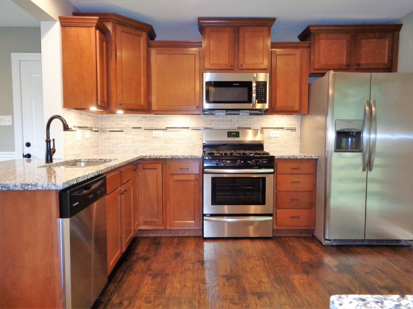 226 Seabury Road Bolingbrook, IL 60440 - Photo 4 of 24 a kitchen with stainless steel appliances granite countertop a stove a sink and a microwave