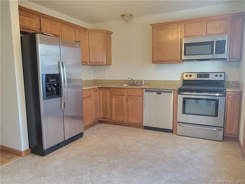21 Bellevue Avenue, Unit B Vernon, CT 06066 - Photo 3 of 14 a kitchen with stainless steel appliances granite countertop a refrigerator and a stove top oven