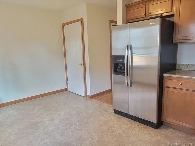a view of an empty room with closet and wooden floor