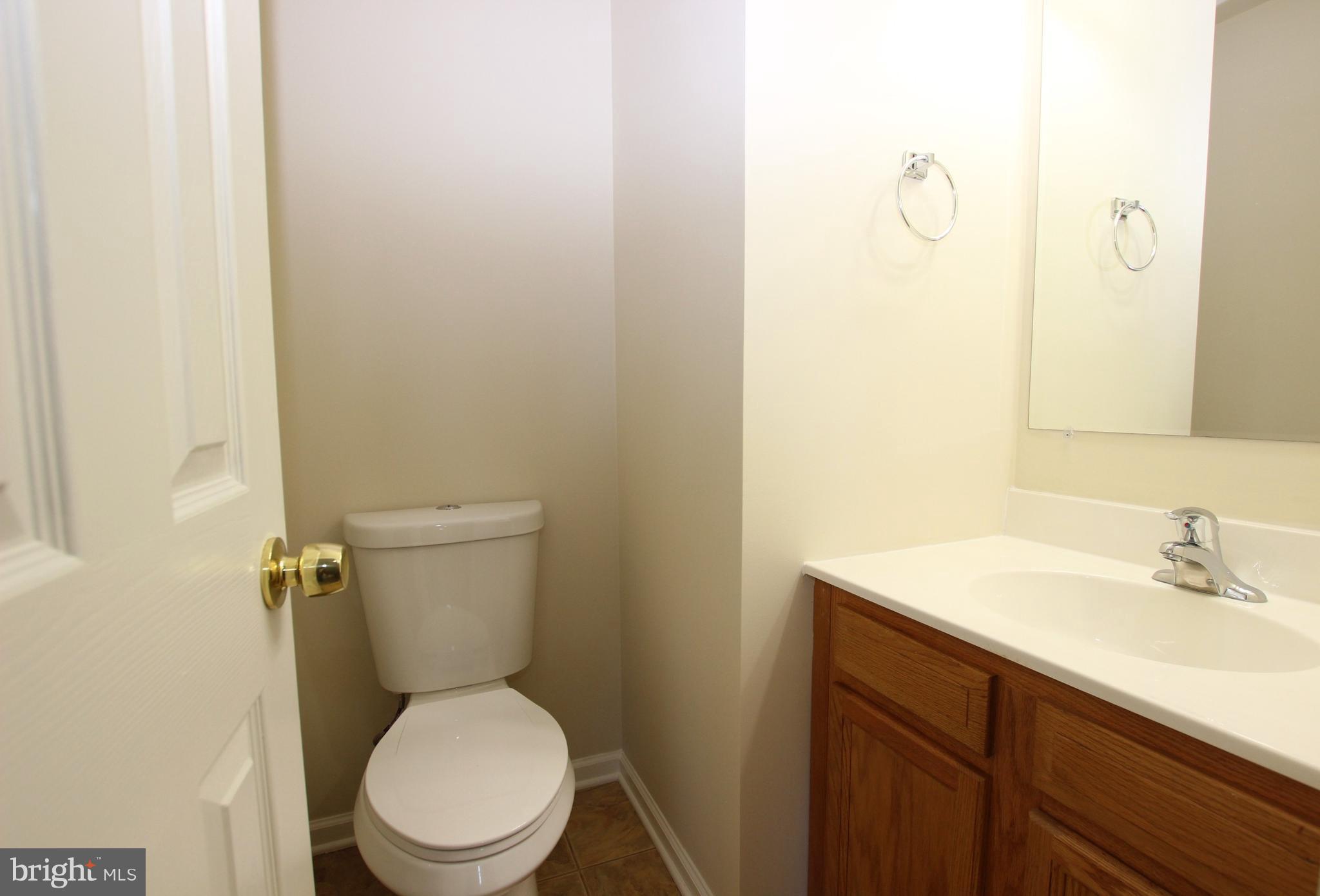 312 East 5th Avenue Ranson, WV 25438 - Photo 11 of 18 a white toilet sitting next to a bathroom sink