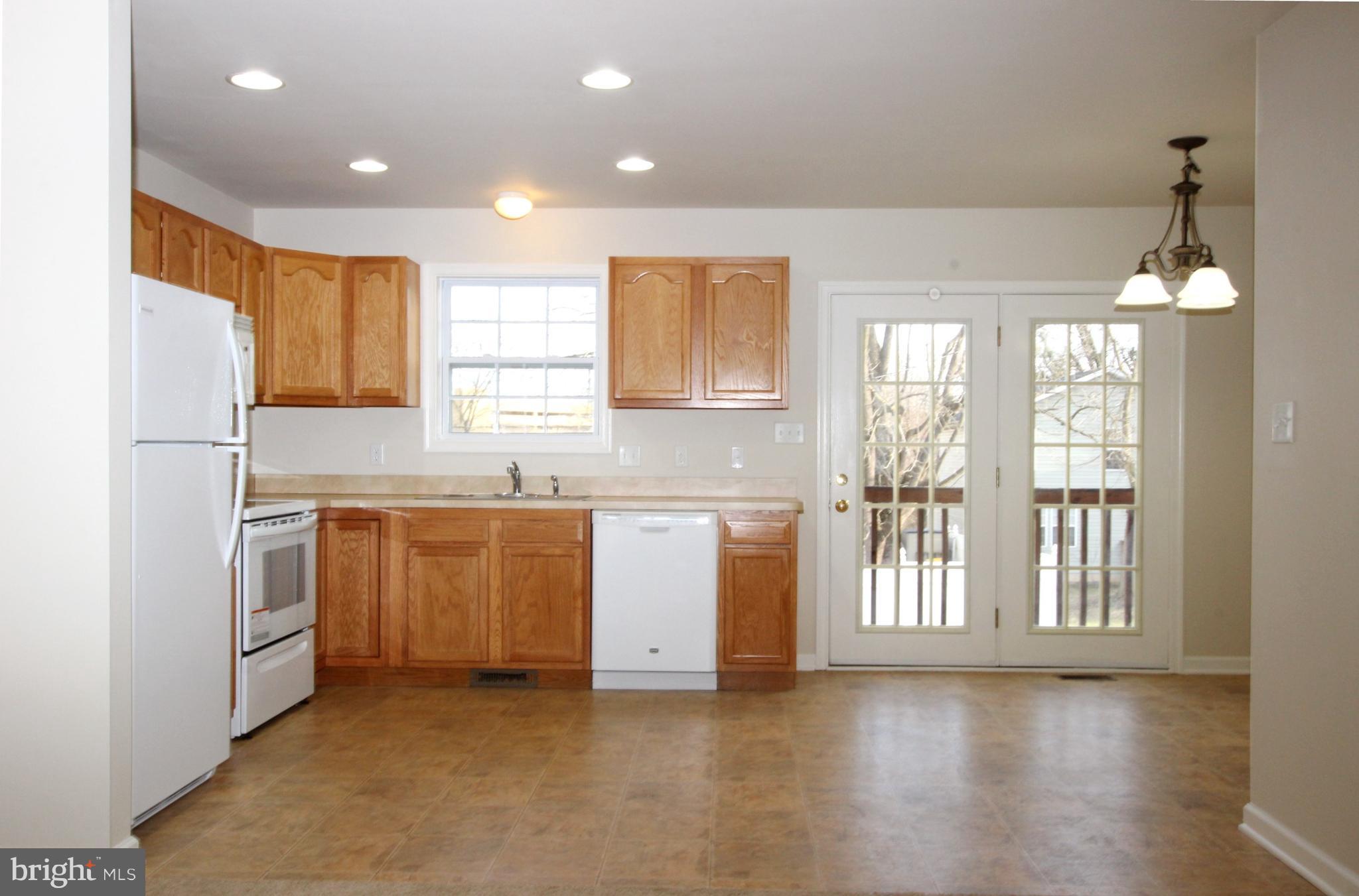 312 East 5th Avenue Ranson, WV 25438 - Photo 8 of 18 a kitchen with granite countertop white cabinets and white appliances