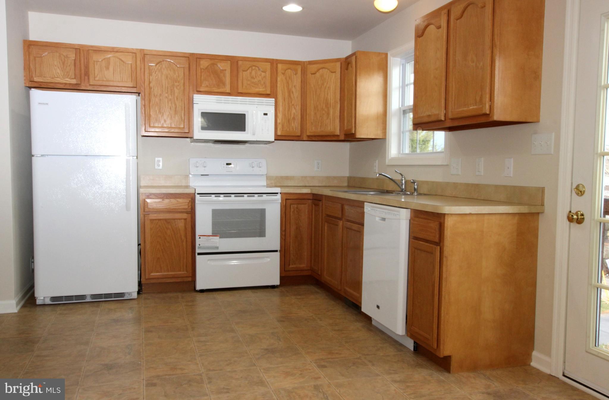 312 East 5th Avenue Ranson, WV 25438 - Photo 9 of 18 a kitchen with stainless steel appliances granite countertop a stove a sink and a refrigerator
