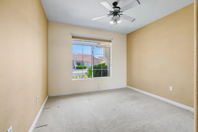 a view of room with window and a ceiling fan