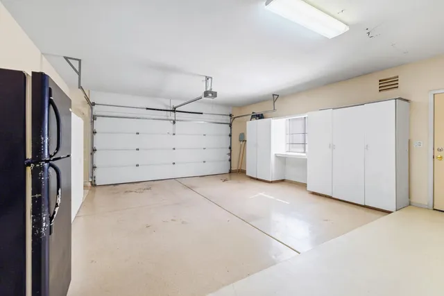 a view of a kitchen with refrigerator and cabinets