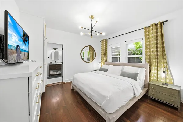 a bedroom with a bed mirror and window