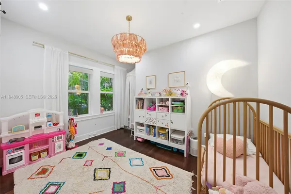 a living room with furniture and a baby crib