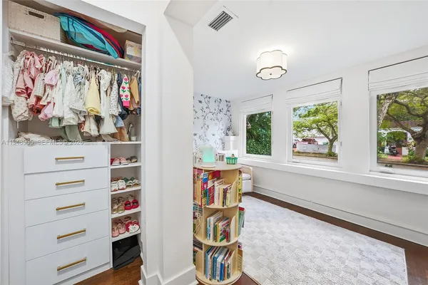 a view of walk in closet with clothes and shoes