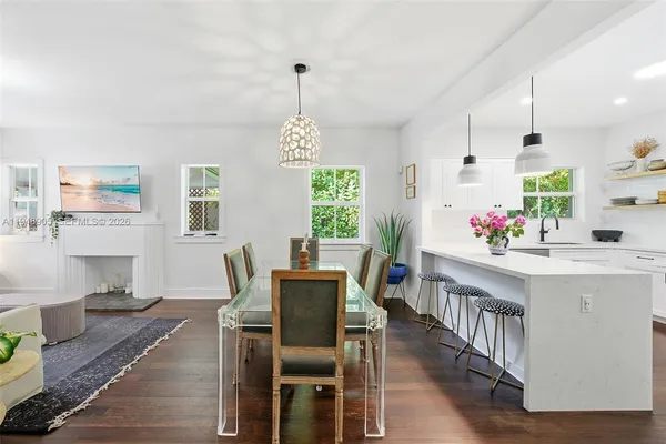 a view of a dining room and livingroom with furniture wooden floor a rug a potted plant and a chandelier