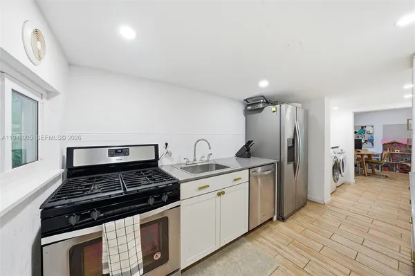 a kitchen with stainless steel appliances a stove a sink and a refrigerator