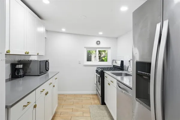 a kitchen with stainless steel appliances granite countertop a sink and a stove