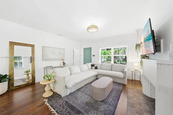 a living room with furniture wooden floor and a flat screen tv