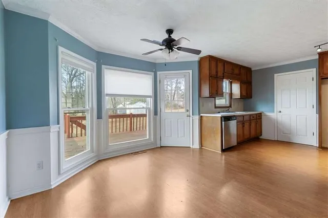 a view of a kitchen with a stove cabinets a ceiling fan and wooden floor