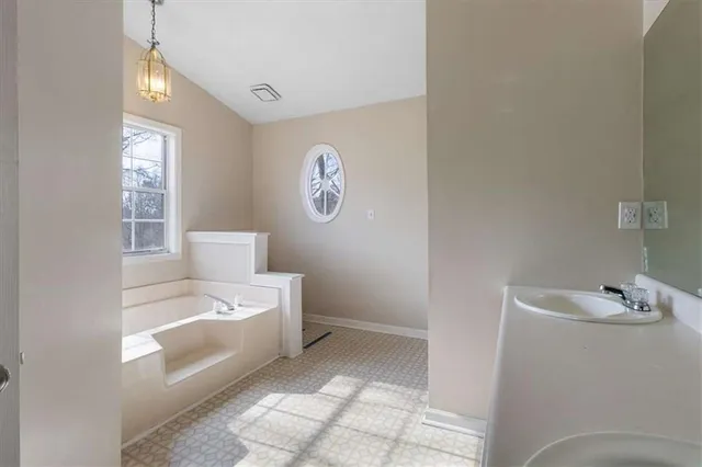 a bathroom with a sink toilet and window