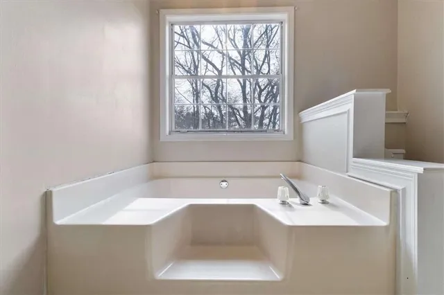 a bathroom with a bathtub a sink and a window