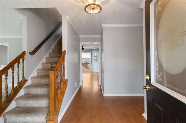 a view of a hallway with wooden floor and staircase
