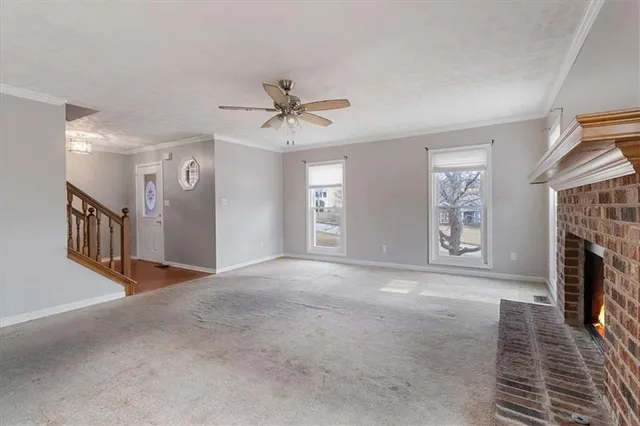 a view of an empty room with window and fireplace