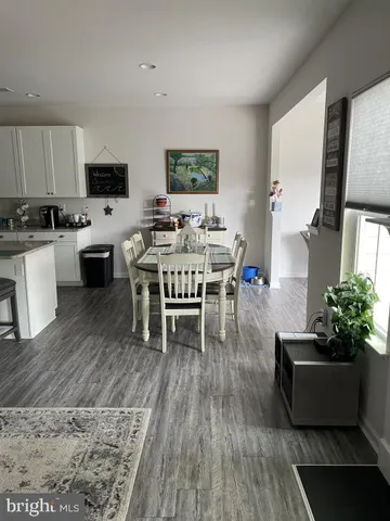 a living room with furniture wooden floor and a kitchen view
